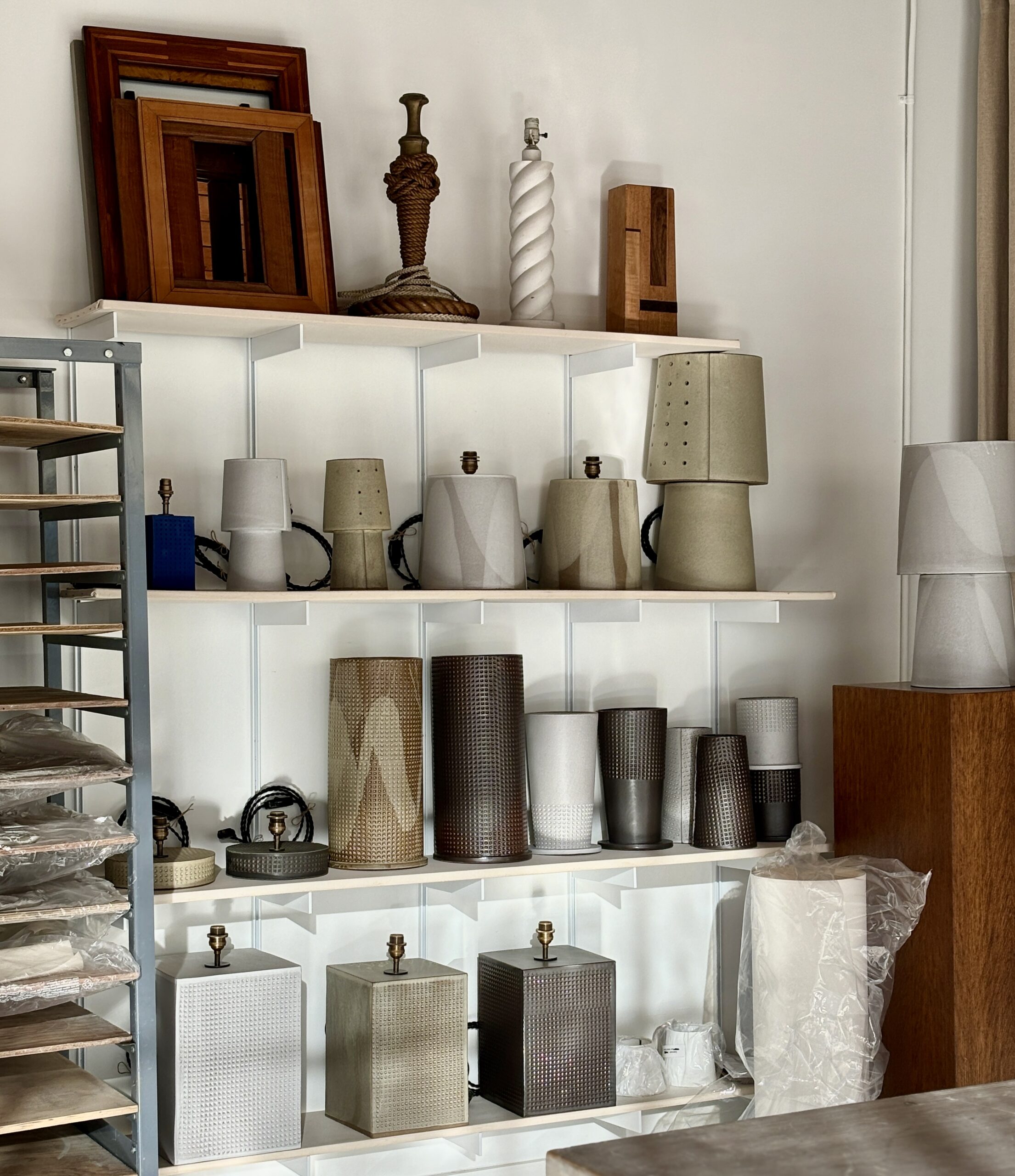 Ceramic lamp bases neatly lined up on wall shelving.