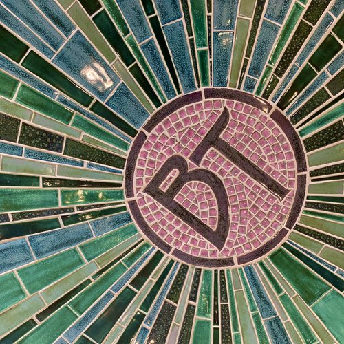 Colorful tiles in a sun formation with the initals BT in the center for Bantam Tile Works.