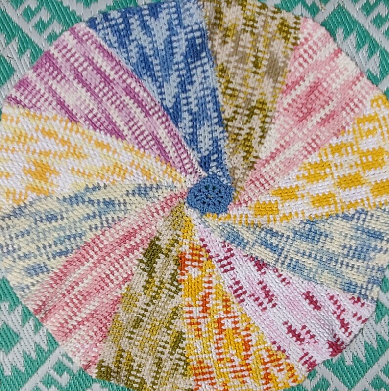 A hand crocheted, multi-colored pinwheel baby blanket.