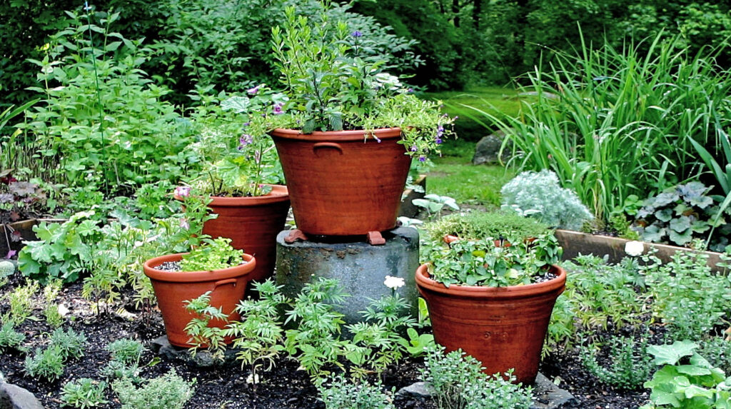 Terracotta pots tiered outdoors with plants flowing from them.