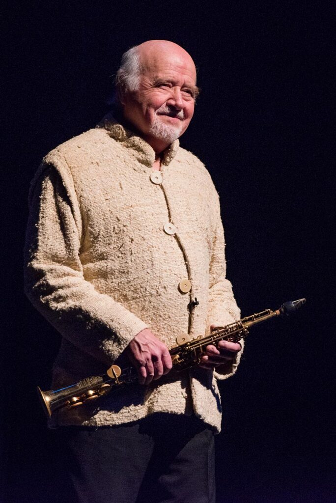 An older man holding an instrument.