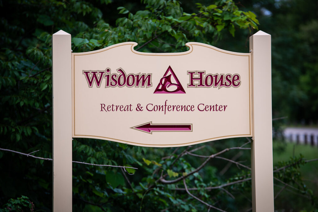 A sign that says Wisdom House Retreat & Conference Center.